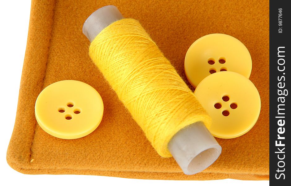 Yellow fabric of a thread and three buttons. Yellow fabric of a thread and three buttons