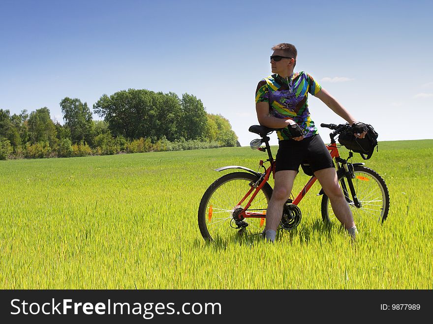 Young Biker tourist relaxation in green field. Young Biker tourist relaxation in green field