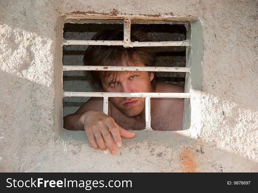 Portrait of a prisoner behind a grate