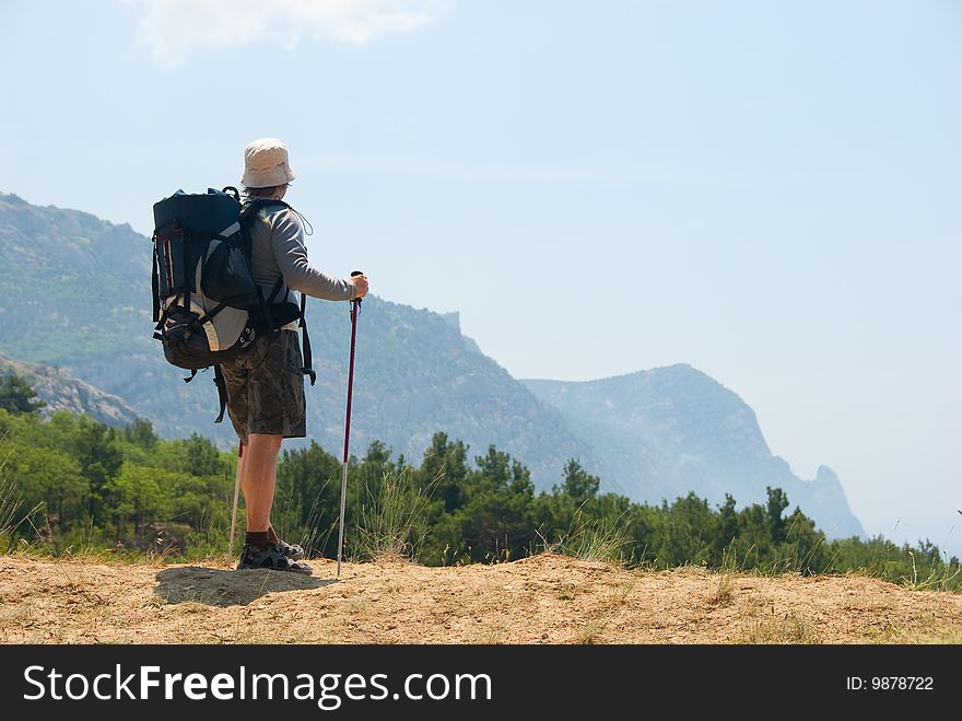 Hiker on a peak enjoys a landscape