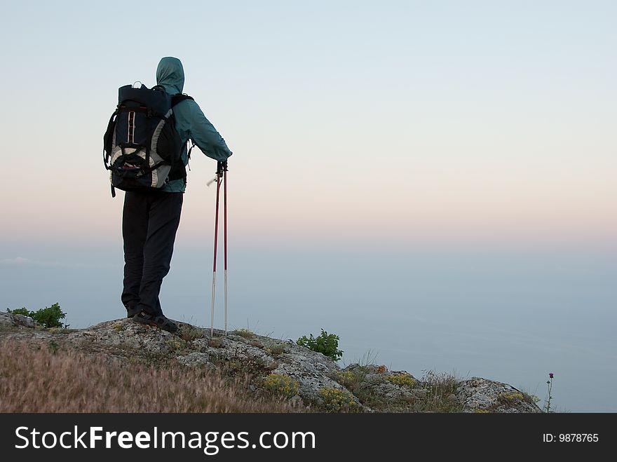 Hiker on a peak enjoys sea landscape