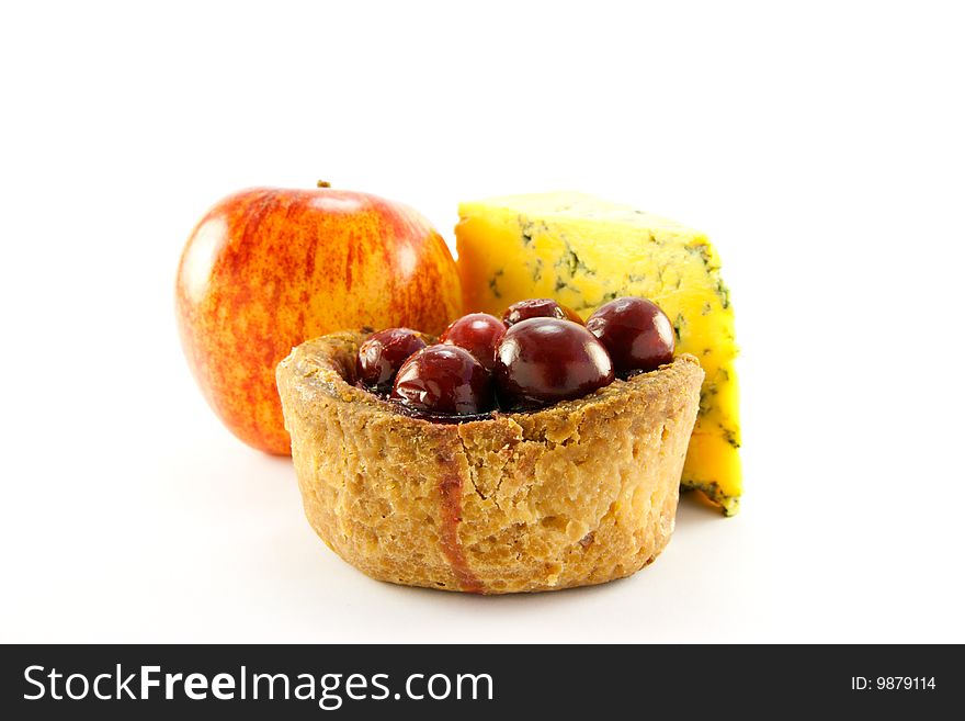 Pork pie with cranberry top with a red apple and slice of blue cheese with clipping path on a white background. Pork pie with cranberry top with a red apple and slice of blue cheese with clipping path on a white background