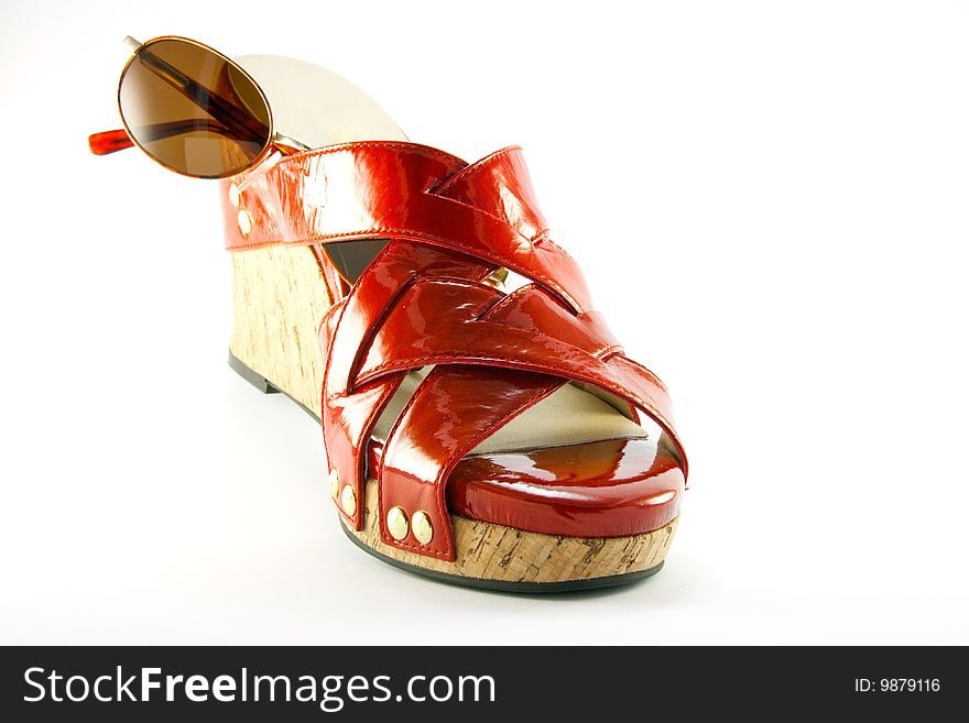 Single red shoe and brown sunglasses with clipping path on a white background. Single red shoe and brown sunglasses with clipping path on a white background