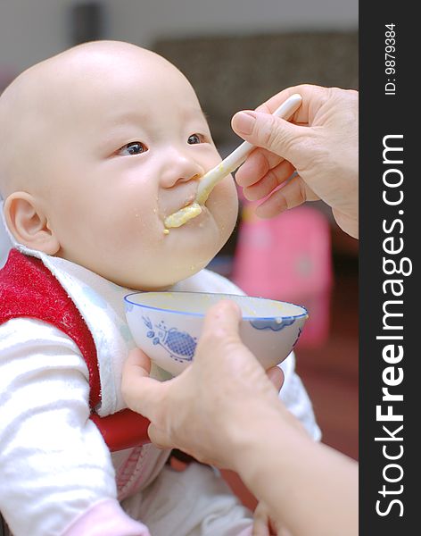 Baby with a spoon in a mouth. Baby with a spoon in a mouth