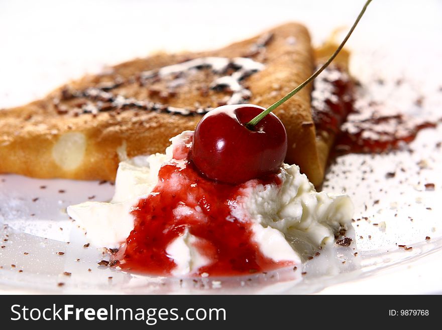 A dessert plate witn pancakes and strawberry