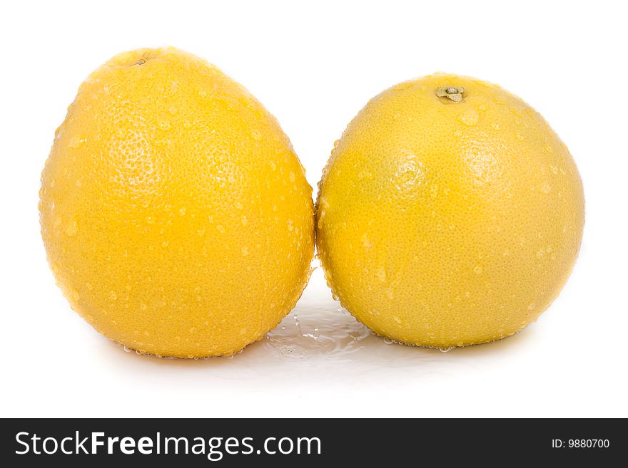 Two grapefruit with water droplets isolated on white background