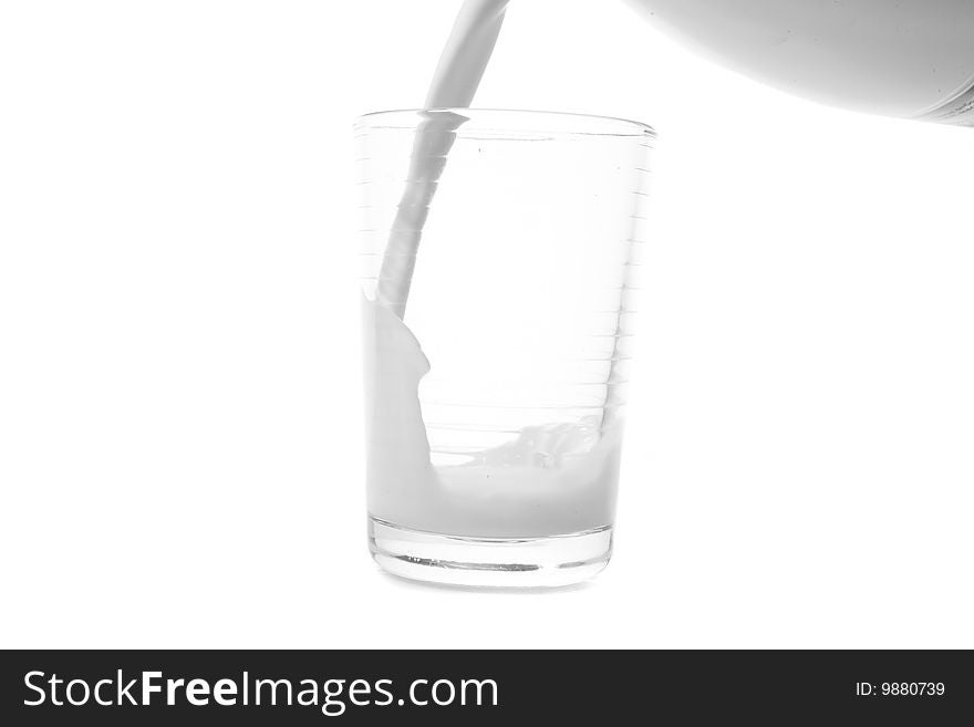 Filling glass with milk on white ground