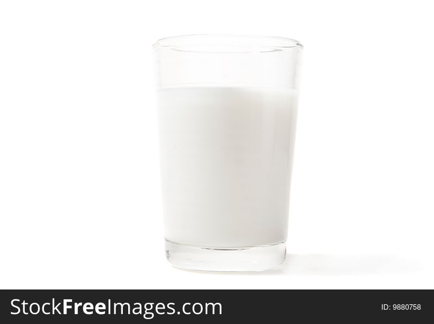 Full glass of milk on white ground
