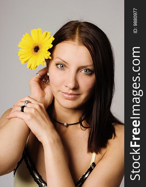An image of a woman with yellow flower