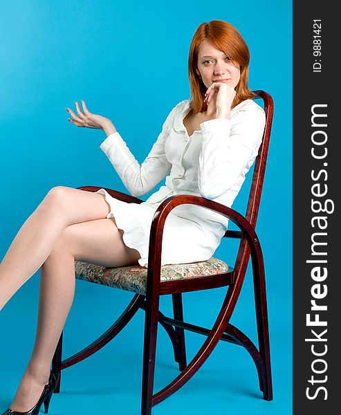 Pretty red girl sitting on high wooden chair