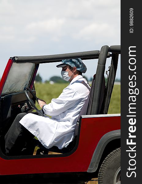 Man driving vehicle wearing clothing to prevent contact with germs. Man driving vehicle wearing clothing to prevent contact with germs.