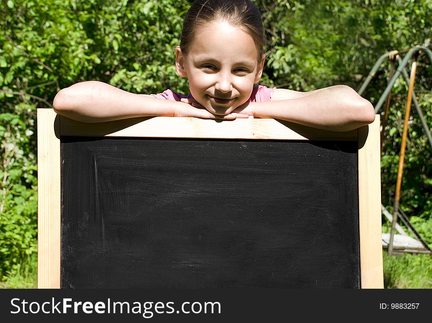 Young Girl Leaning On A Blackboard