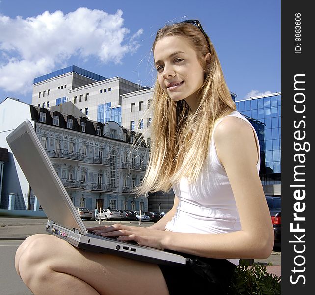 Happy collegian with laptop computer near a modern building. Happy collegian with laptop computer near a modern building