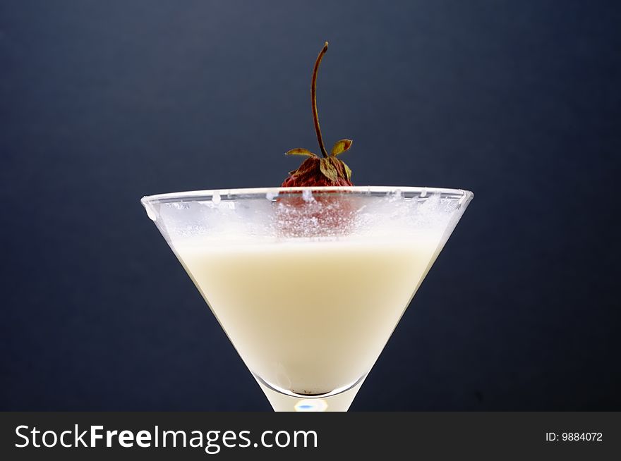 A strawberry dropped into the glass of milk. A strawberry dropped into the glass of milk