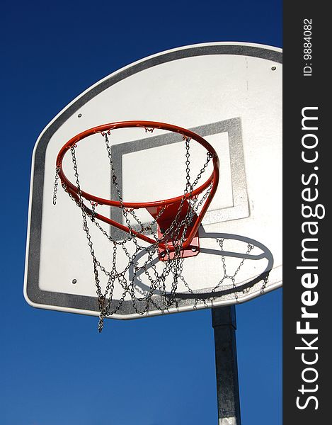 A basketball case seen from below, with a blue sky behind it. A basketball case seen from below, with a blue sky behind it