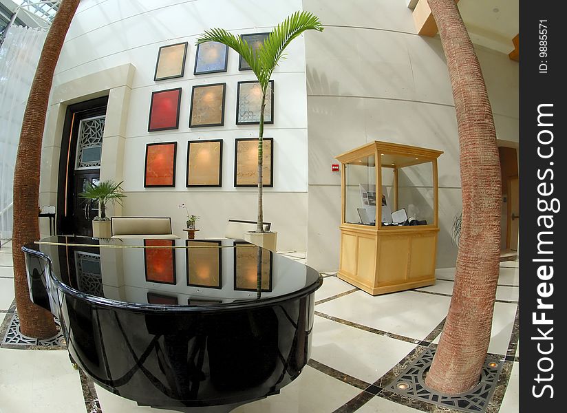 Black grand piano in lobby setting.