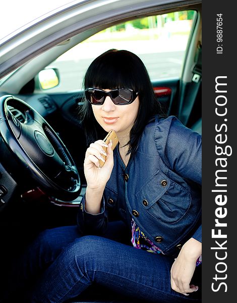Beautiful young businesswoman with cellphone in her car after work. Beautiful young businesswoman with cellphone in her car after work