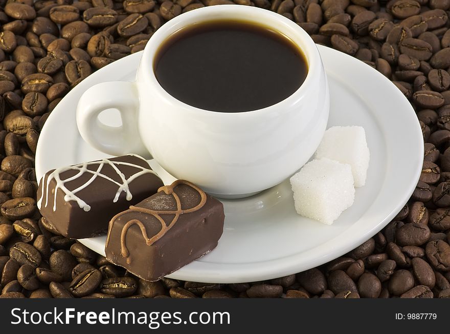 Coffee cup and candy for roasted beans