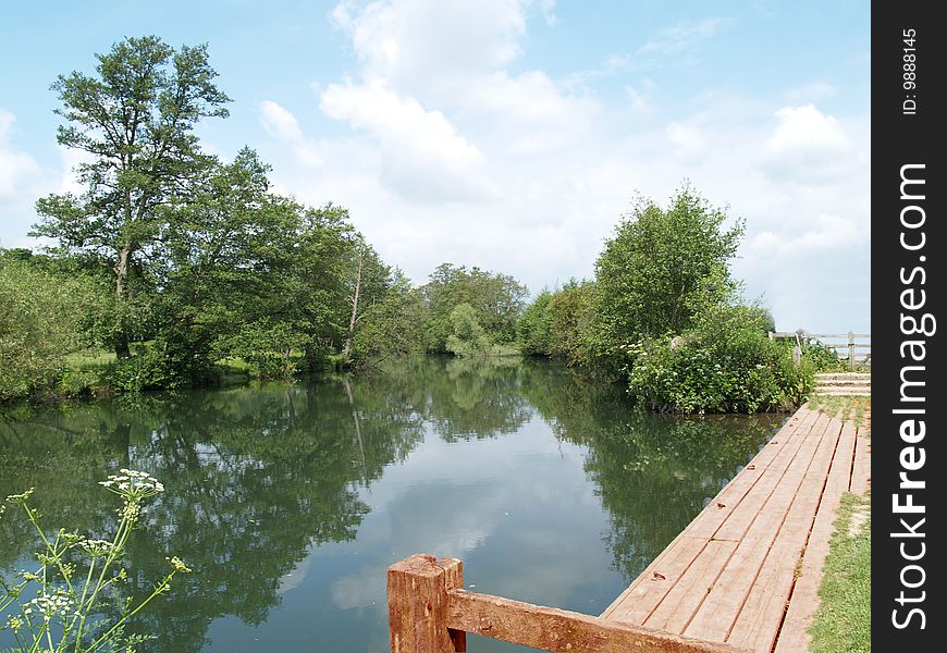 A landing stage awaits boats and customers, and the river quietly flows. A landing stage awaits boats and customers, and the river quietly flows