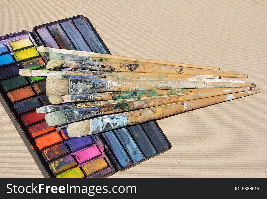 A selection of paint brushes on watercolor