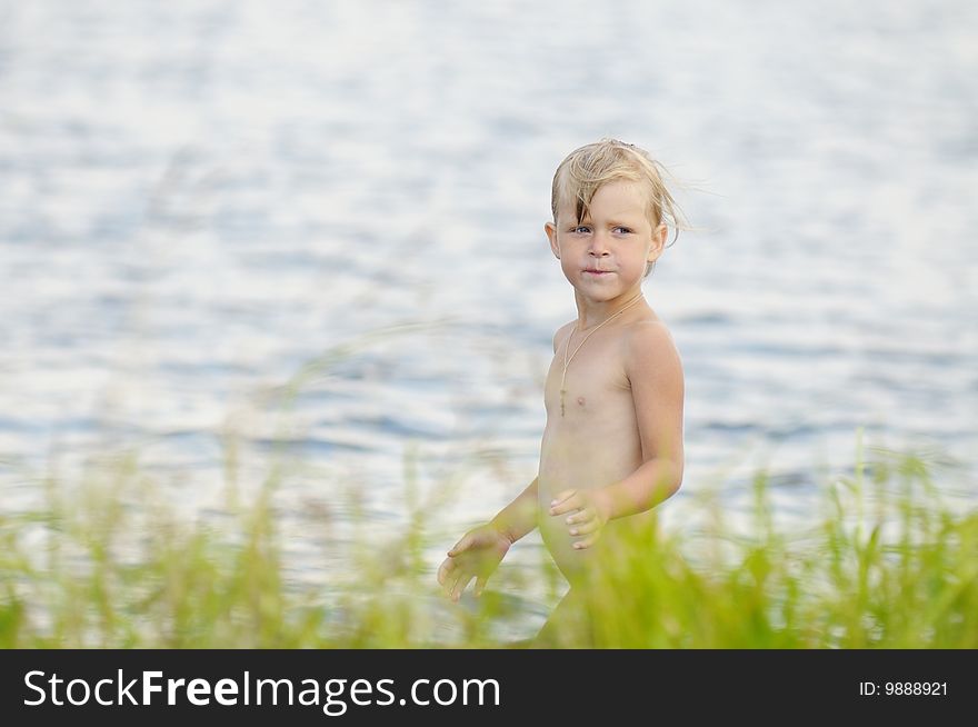 The little girl costs on river bank