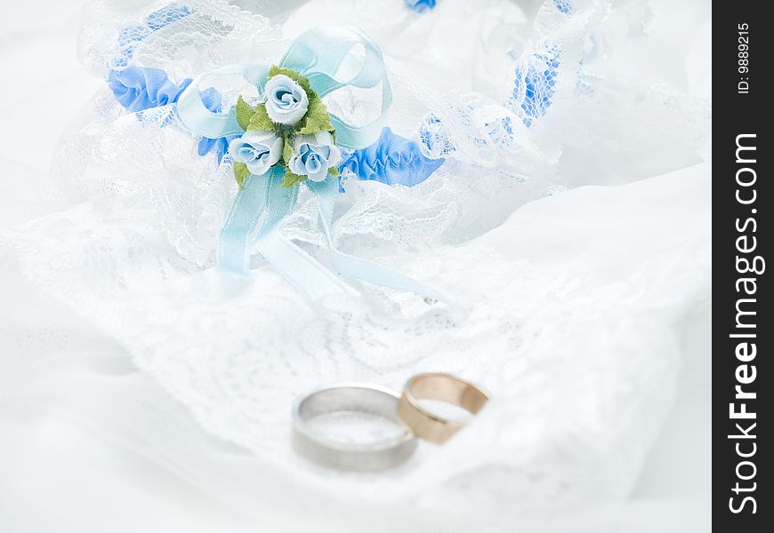 Closeup of wedding rings on a white veil