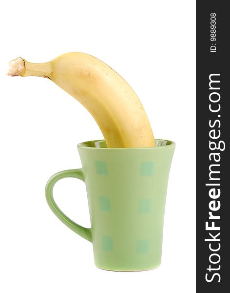 Yellow banana in a cup as a symbol of the squeezed out fresh juice.