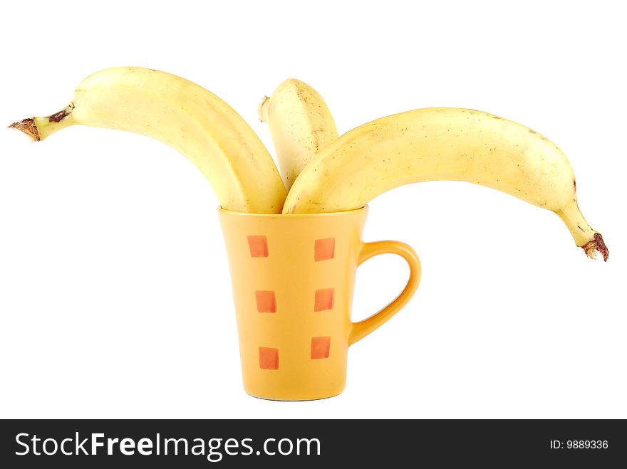 Yellow banana in a cup as a symbol of the squeezed out fresh juice.