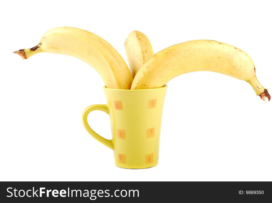 Yellow banana in a cup as a symbol of the squeezed out fresh juice.