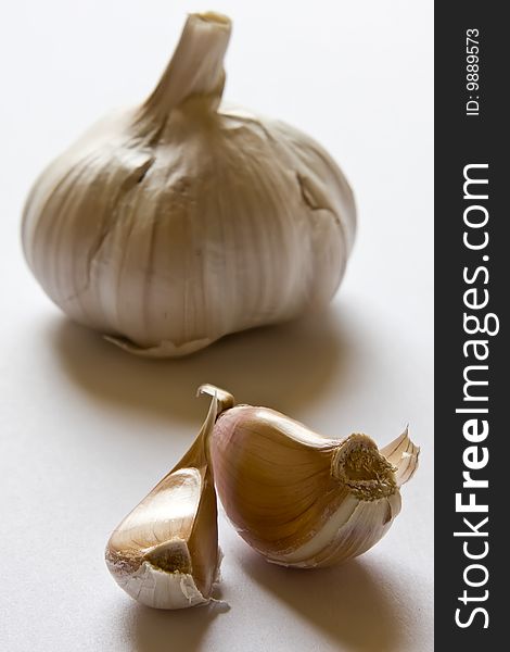 Garlic on  white background with shade. Focus on cloves. Garlic on  white background with shade. Focus on cloves.