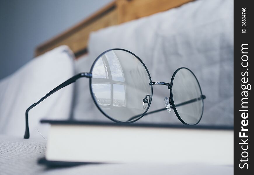 Eyeglasses And Book In Bedroom For Reading And Relax.