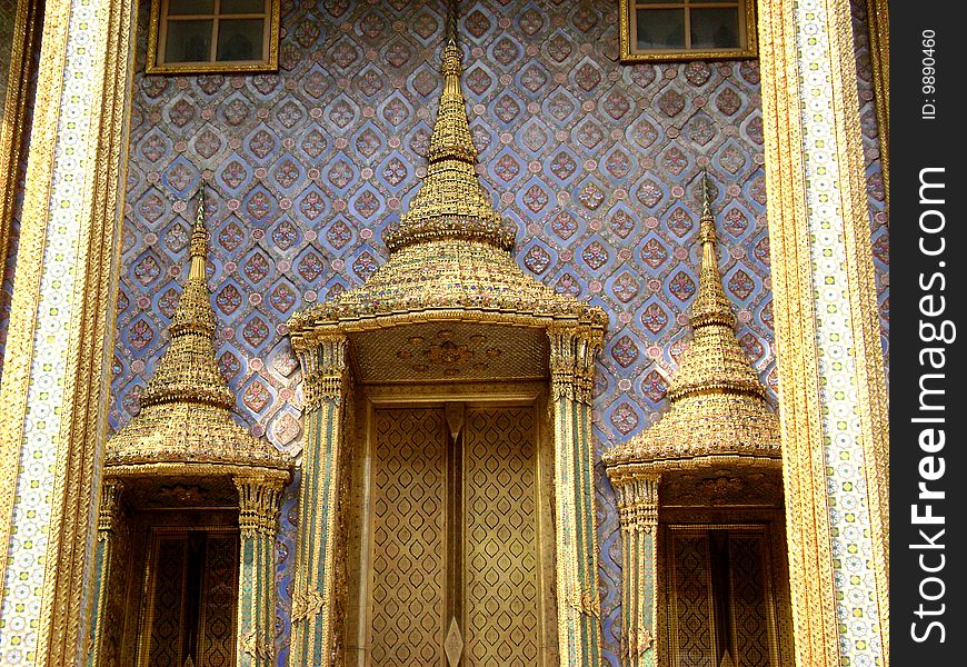 Three golden doors of a purple-walled temple; Emerald Buddha, Bangkok. Three golden doors of a purple-walled temple; Emerald Buddha, Bangkok