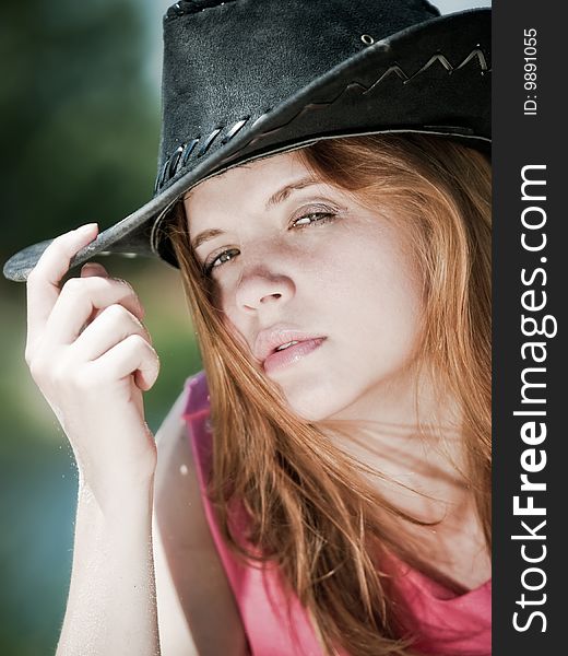 Closeup portrait of young pretty girl in cowboy hat