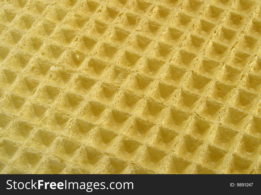 Yellow waffle macro background textured top surface. Yellow waffle macro background textured top surface