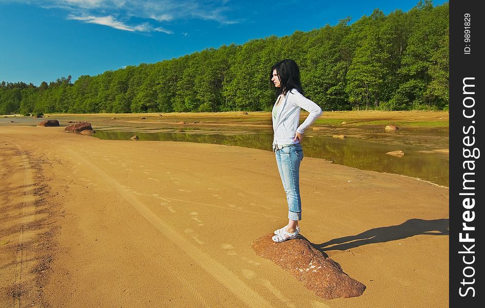 Young girl on the shore of the Gulf is looking into the distance