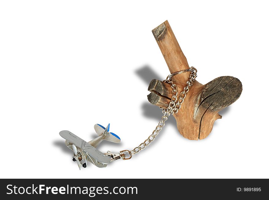 Miniature model of old biplane constrained with chain and log. Isolated with clipping path. Miniature model of old biplane constrained with chain and log. Isolated with clipping path