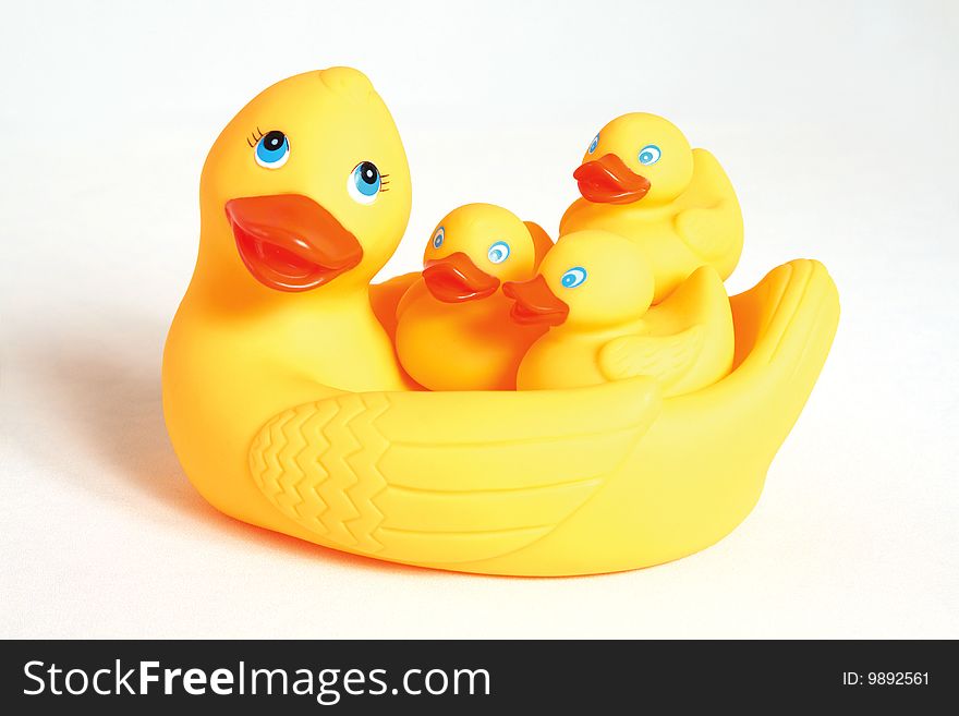 A toy duck, yellow plastic, with duckling (nestlings).