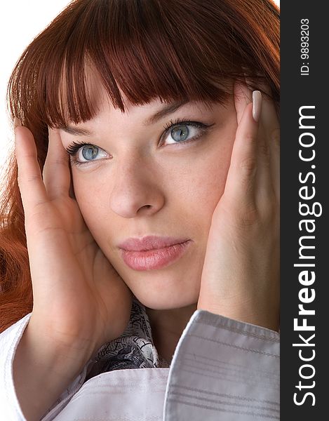 Red haired girl holding face by her hands close-up. Red haired girl holding face by her hands close-up