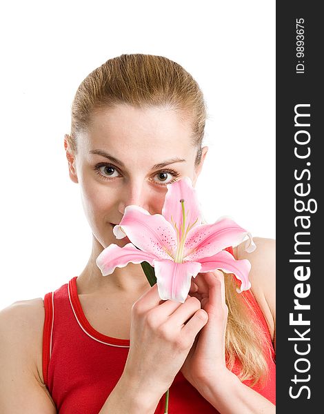 A nice blond girl in red posing with a pink lily near her face on a white background. A nice blond girl in red posing with a pink lily near her face on a white background