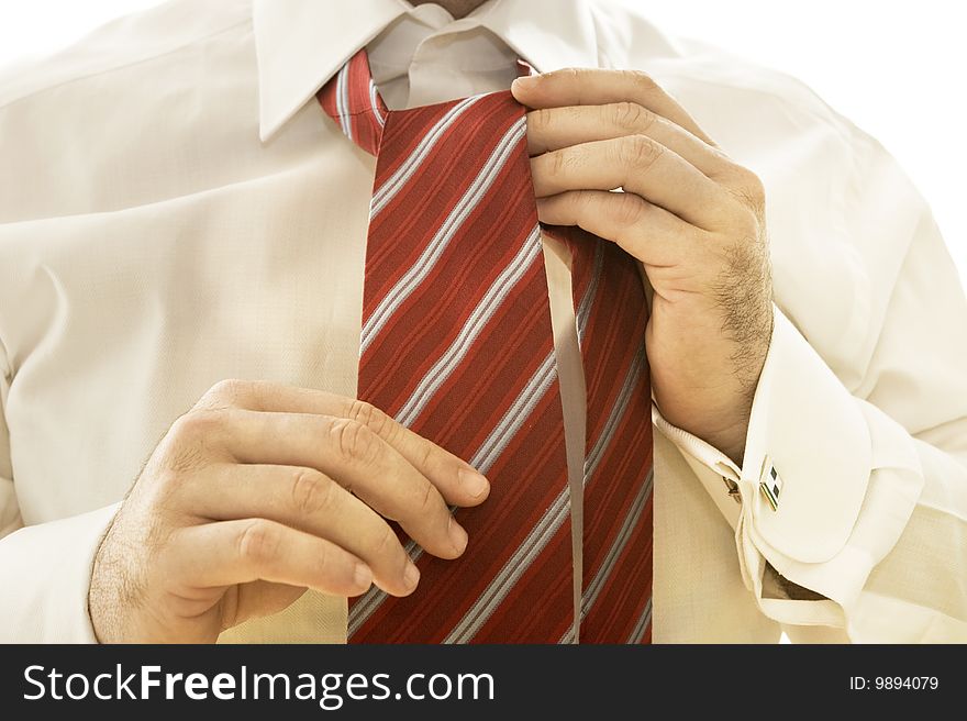 Handsome young businessman adjusting tie