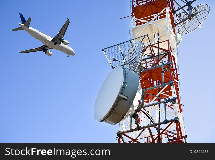 Close up of a television antenna with the background a plane in landing. Close up of a television antenna with the background a plane in landing