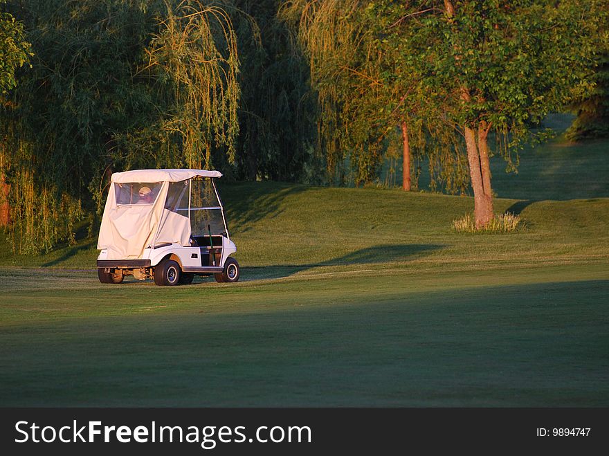 Man driving a golf cart on a nice sunny day. Man driving a golf cart on a nice sunny day