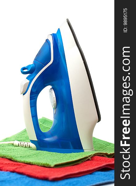 Flat smoothing iron staying on coloured bath towels