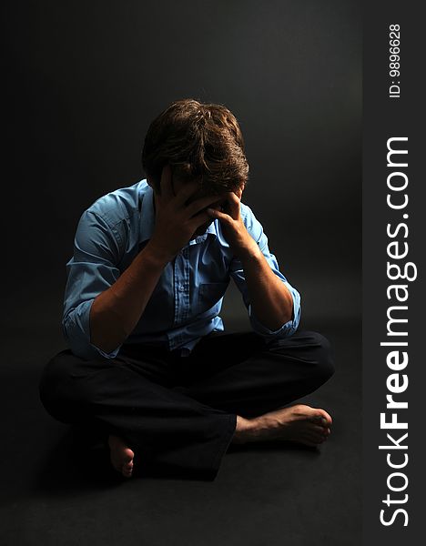 Man meditating in low key over a black background