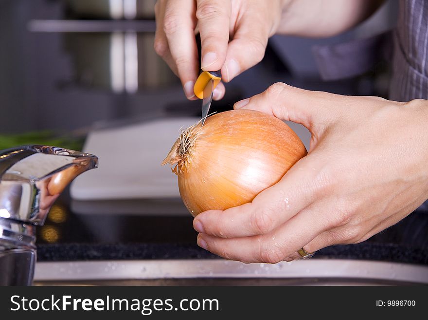 Peeling an onion in the kitchen sink