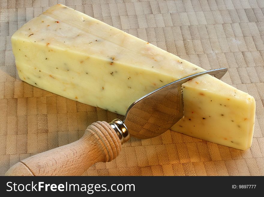 Cheese wedge on bamboo cutting board with knife. Cheese wedge on bamboo cutting board with knife