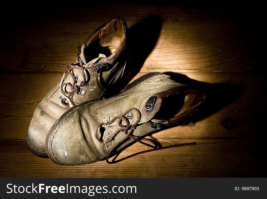 Pair of old paint splattered boots in dark. Pair of old paint splattered boots in dark