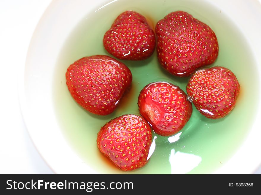 Red strawberries dessert in green jelly, homemade sweet thing