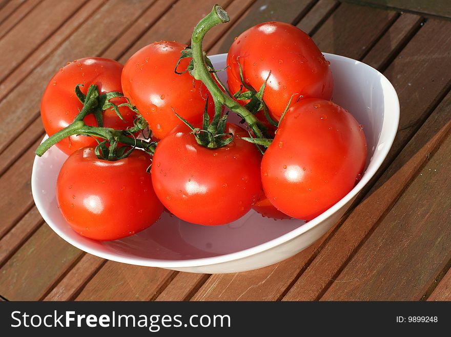 Six organic tomatoes in bowl on the garden table. Six organic tomatoes in bowl on the garden table