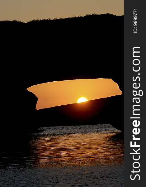 Sunset over a rocky arch on a mediterranean island. Sunset over a rocky arch on a mediterranean island